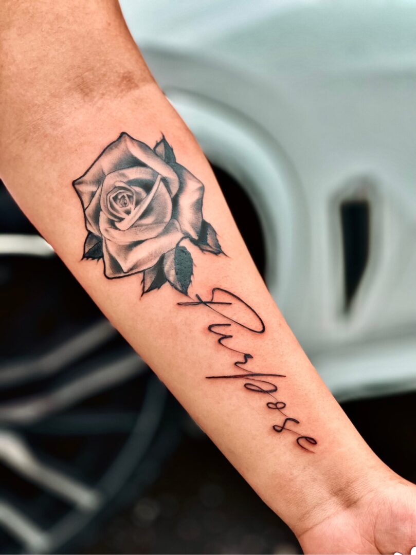 A tattoo of a rose with the word 